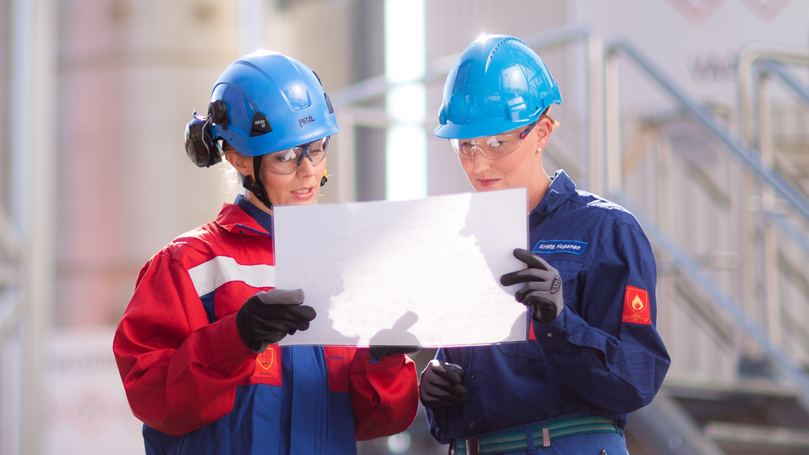 Two factory workers looking at a drawing.