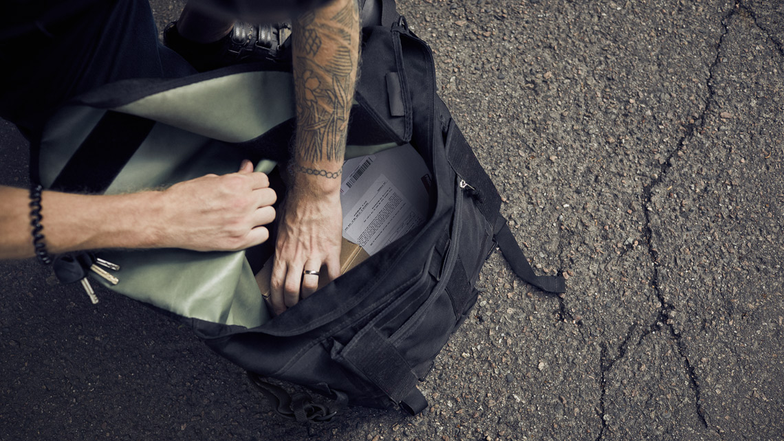 A person reaching to a box in the bag.