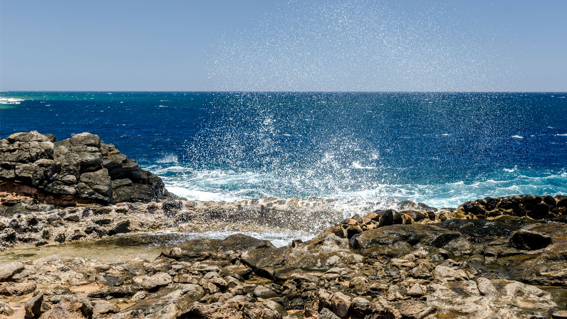 Seawaves splashing againts rocks in the beach.