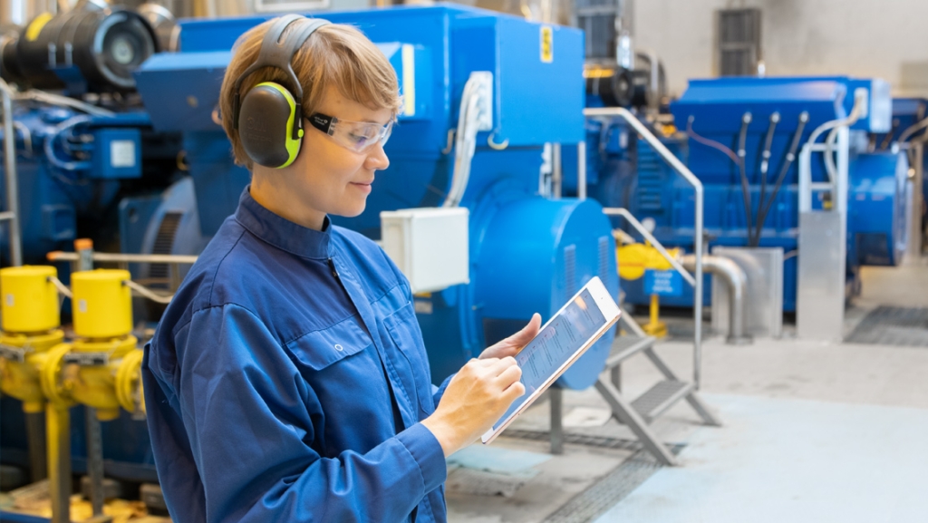 A factory worker looking at a tablet dashboard.