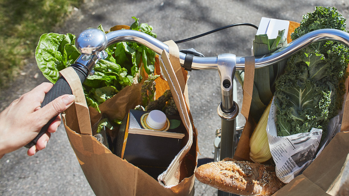 Paper grocery shopping bags on a bicycle rail.