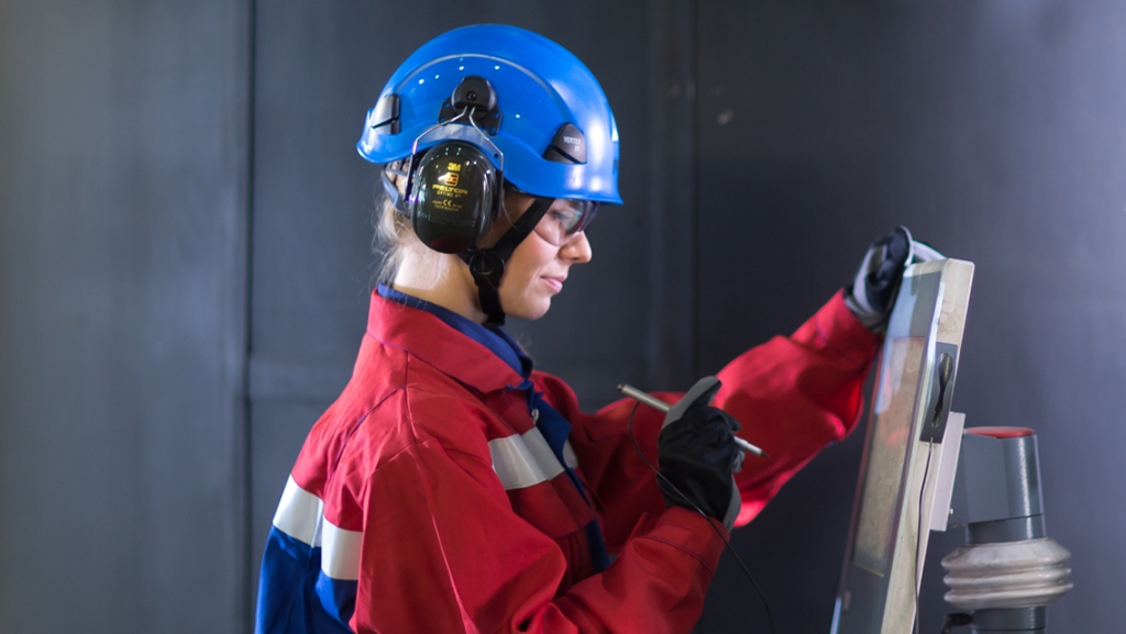 A factory worker checking monitor.