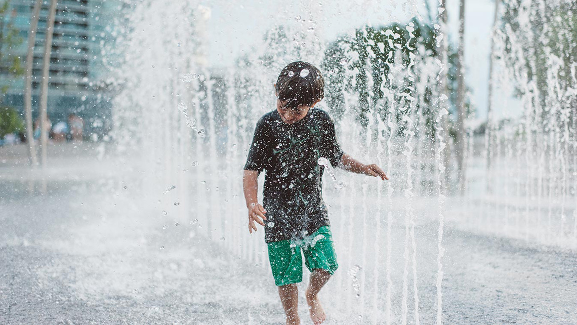 A child in a city fountain.