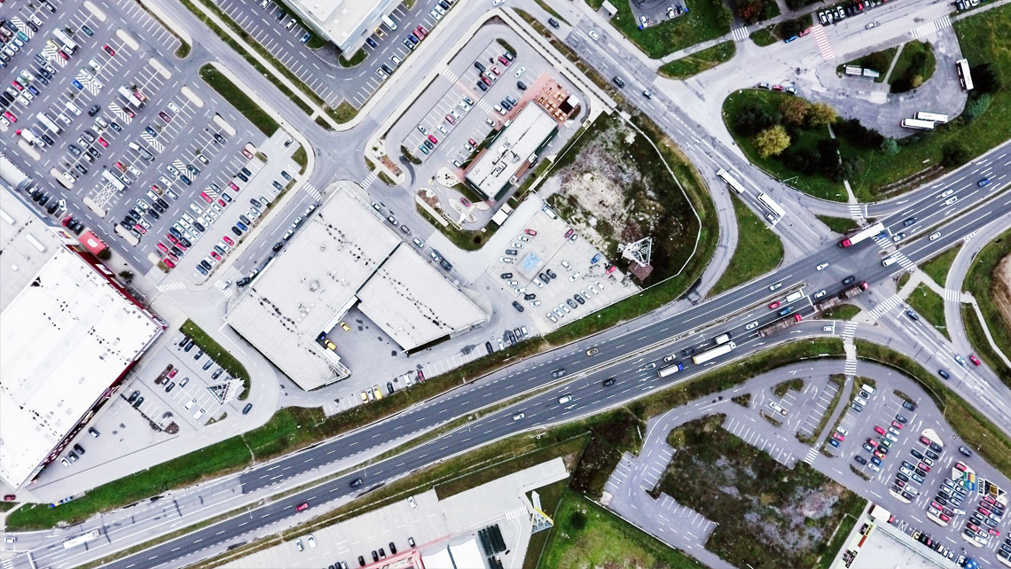 An aerial view on city roads and parking areas.