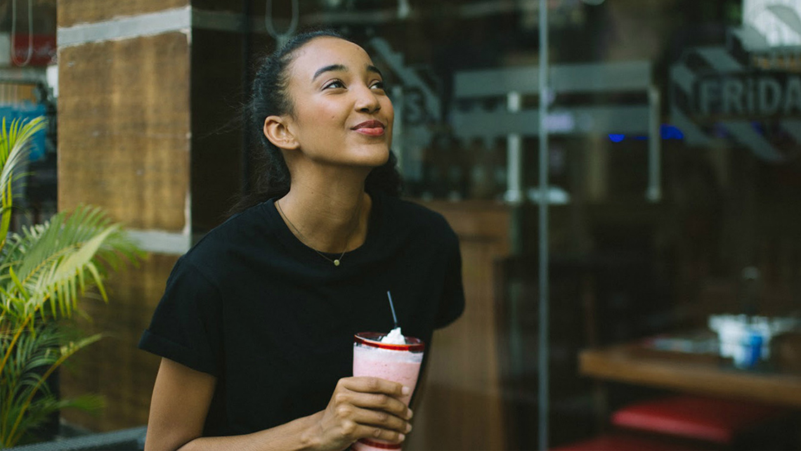 A person enjoying milk shake in a café.