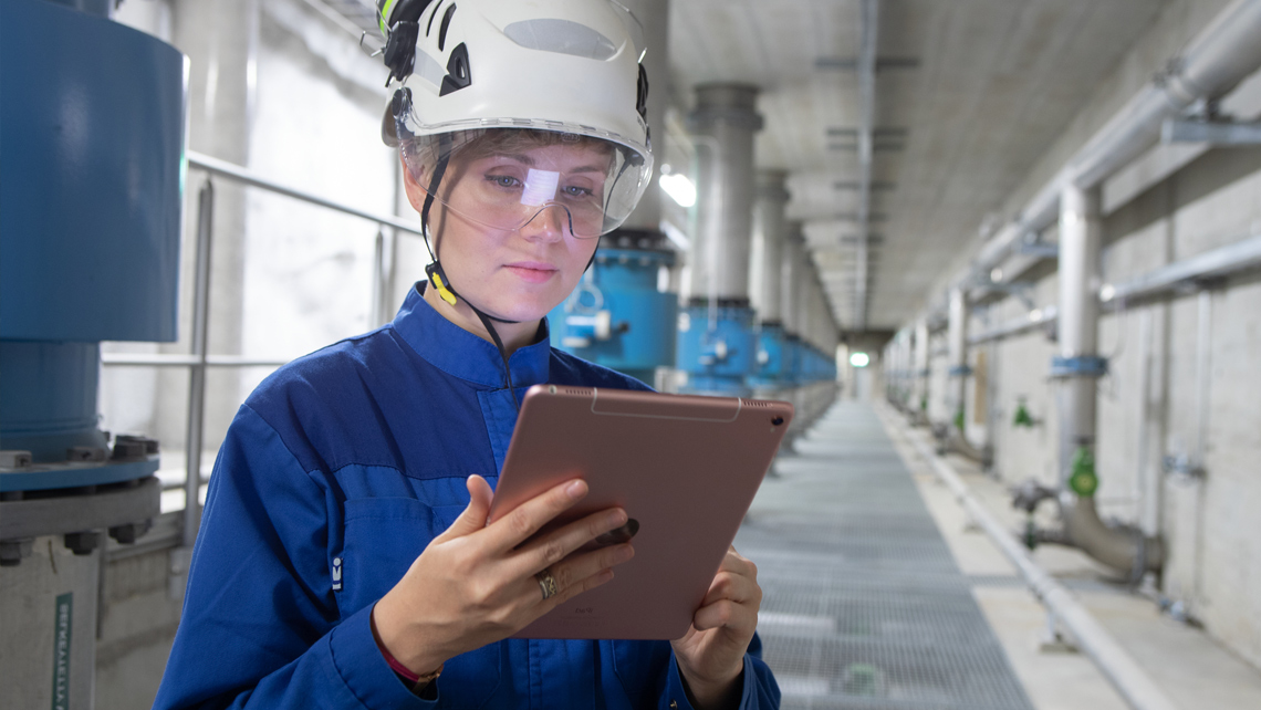 A worker holding a tablet in a factory.
