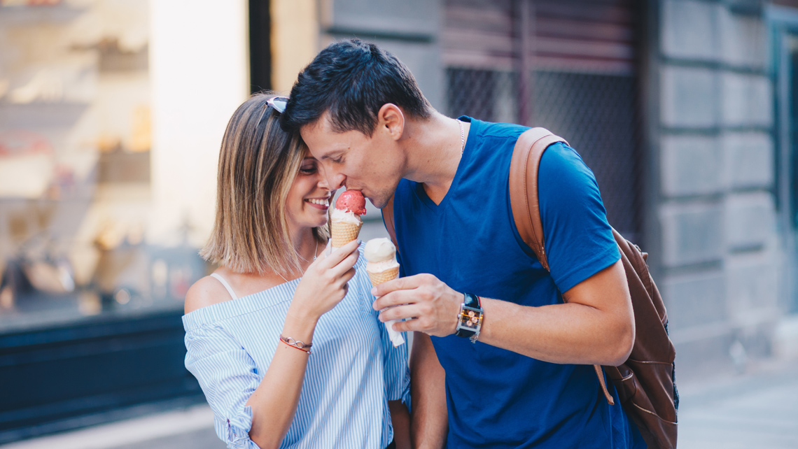 Two persons eating ice-cream in the street.