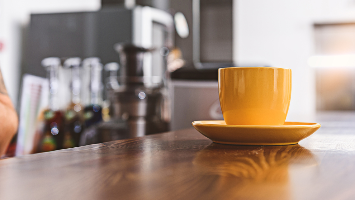 Yellow coffee cup on a wooden table.