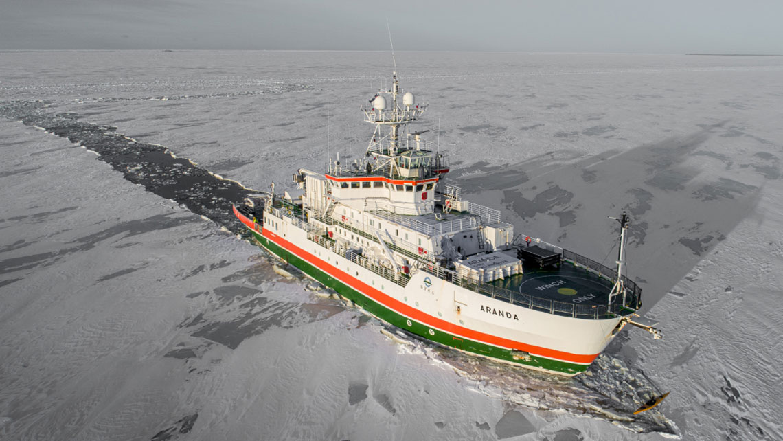 Aerial view of icebreaker vessel in a frozen sea.