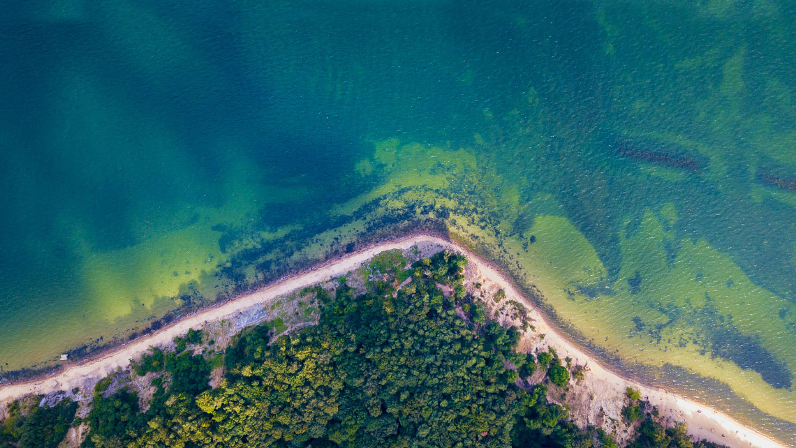 Aerial view on a beach with tuqouise water and jungle.