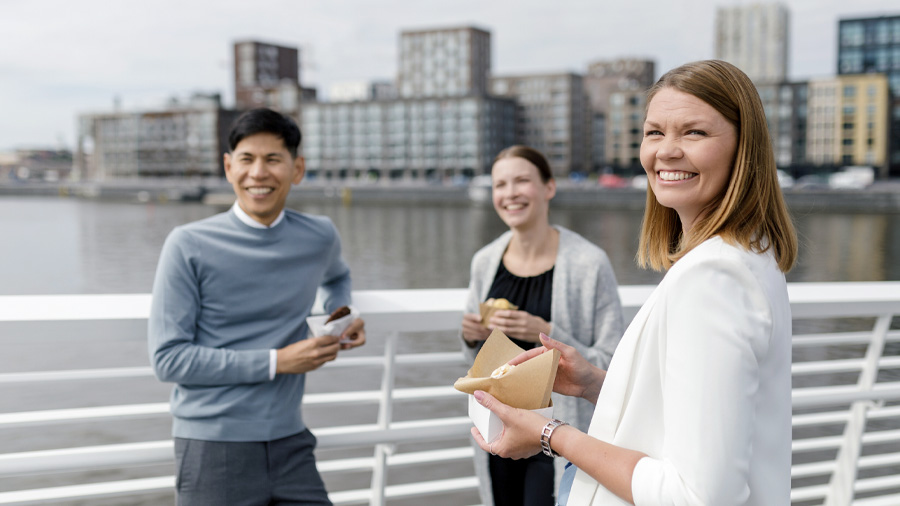 Three colleagues having a snack by the sea.