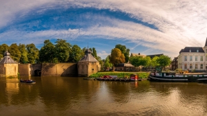 Cityscape of Dutch town Breda with river and historic buildings on a sunny day.