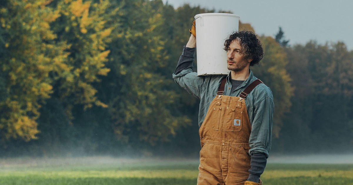 A farmer holding a bucket.