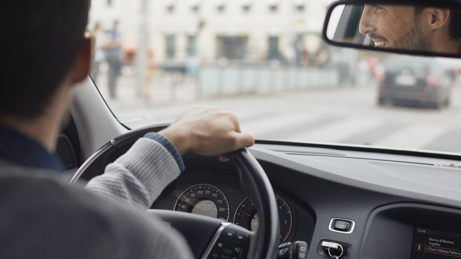 A person driving a car and smiling.