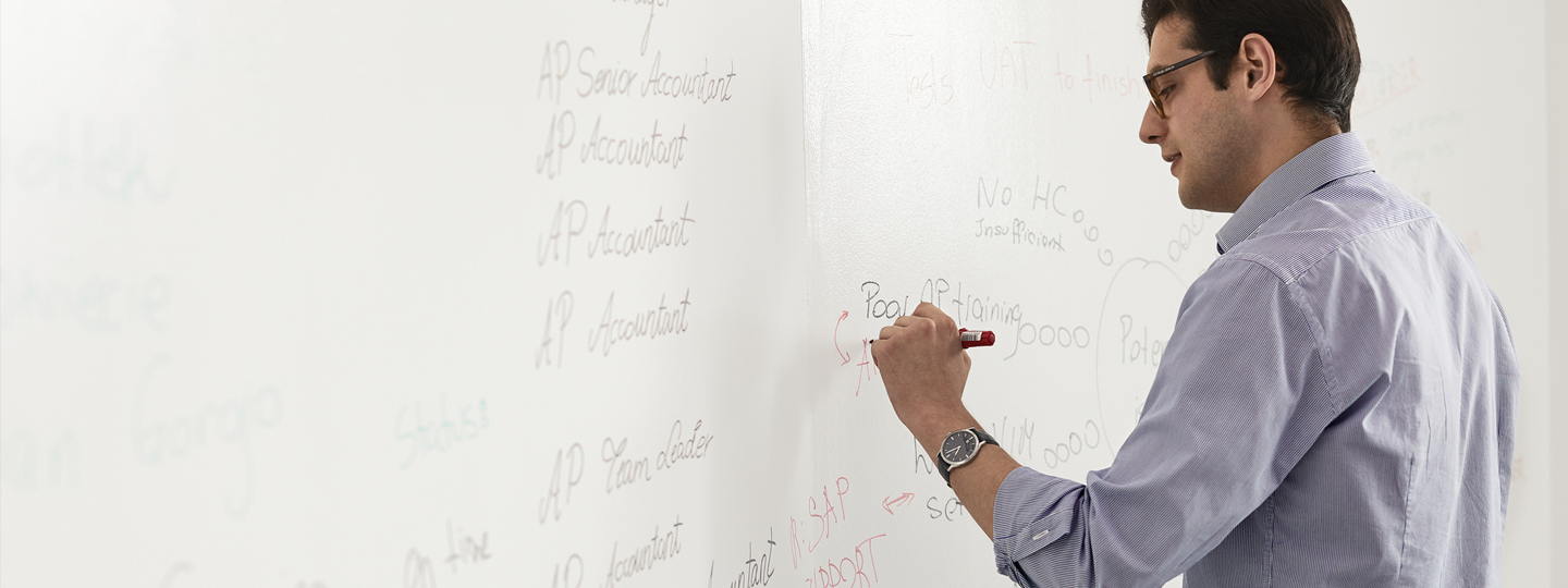 A person writing to a whiteboard.