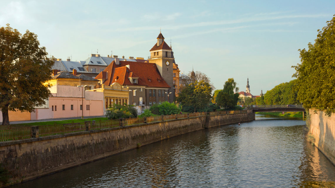 Panormaic view of Morava river in olomouc czech with tress and ancient buildings.