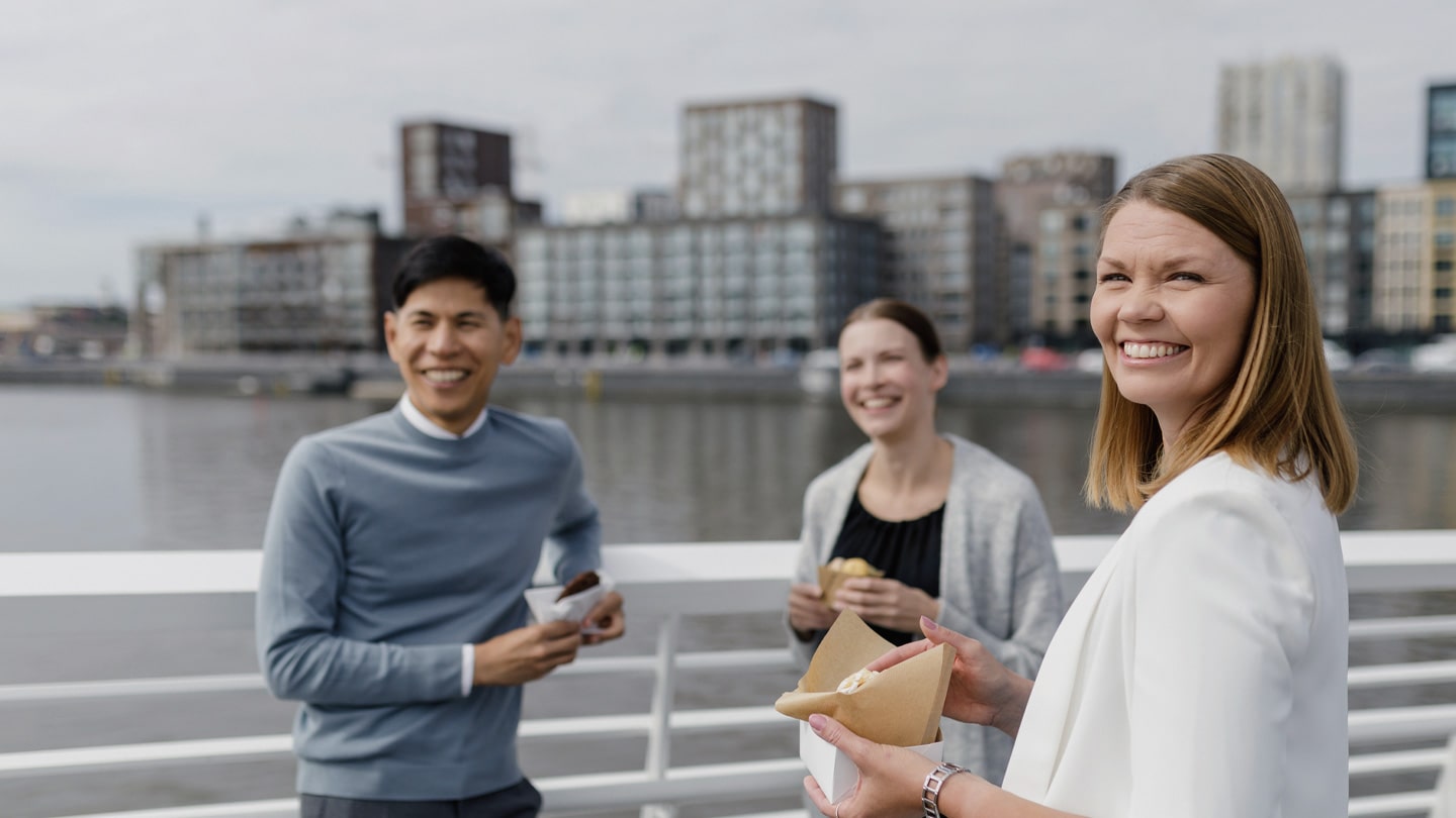 People enjoying with takeaway sandwiches on a bridge.