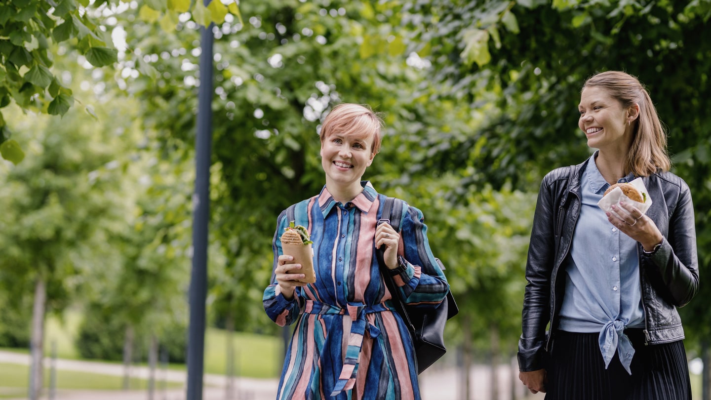People walking with takeaway sandwiches.