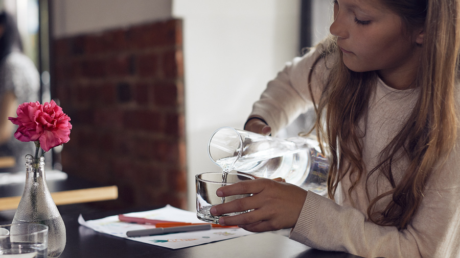 A person pouring water to a glass.