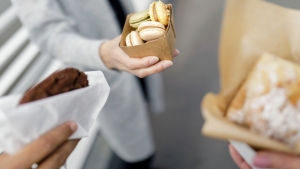 Persons holding pastries in paper and board packages, featuring Kemira's barrier chemistry.