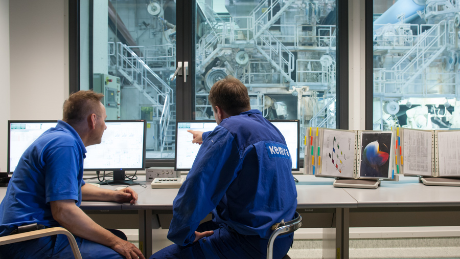 Two persons viewing a monitor dashboard in the factory.