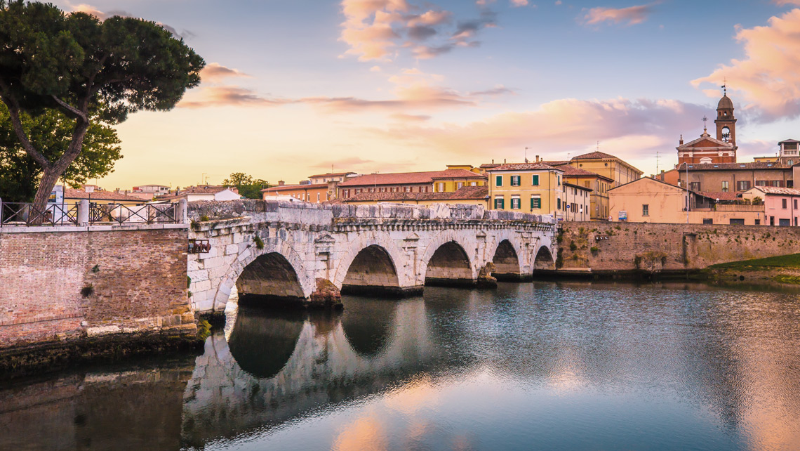 Rimini city landscape and old bridge over the river.