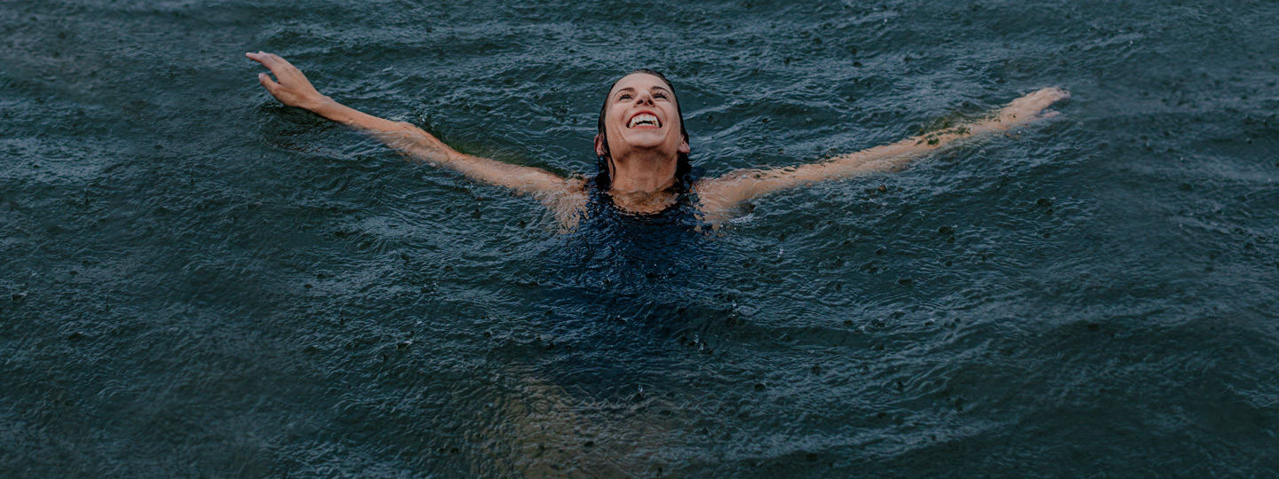 A person swimming in water and smiling.