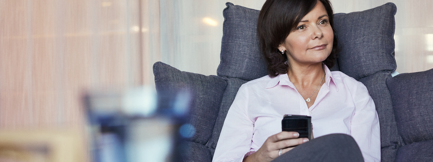 A person sitting on the sofa with a mobile device.