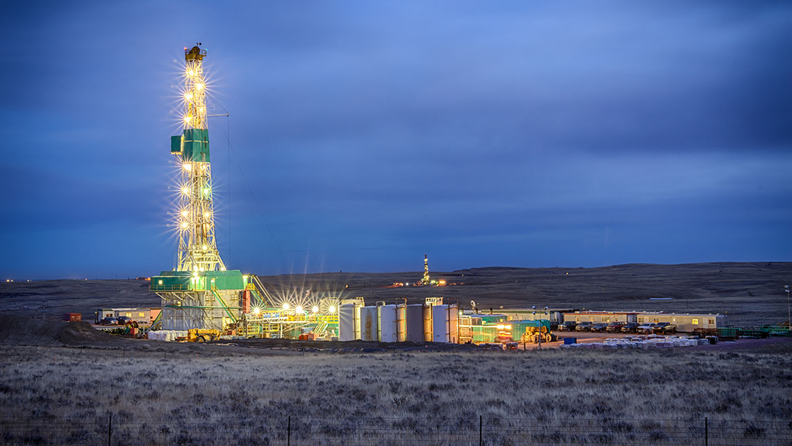 Drilling fracking rig at night with bright lights