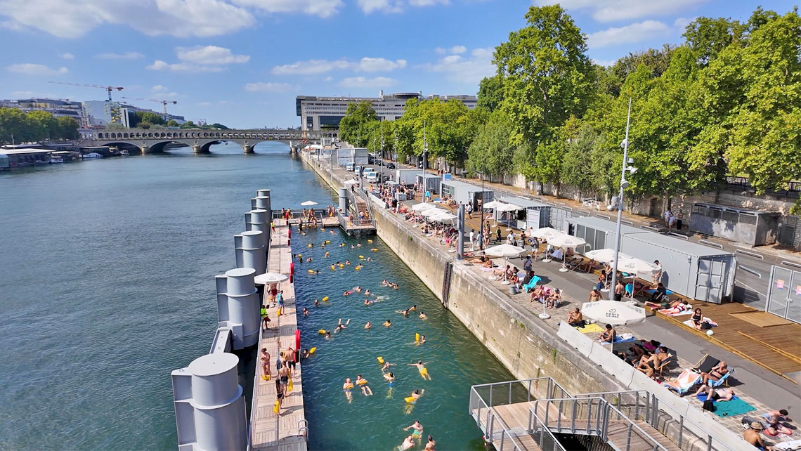 People enjoying the Seine River near Pont de Bercy in Paris on a sunny day.