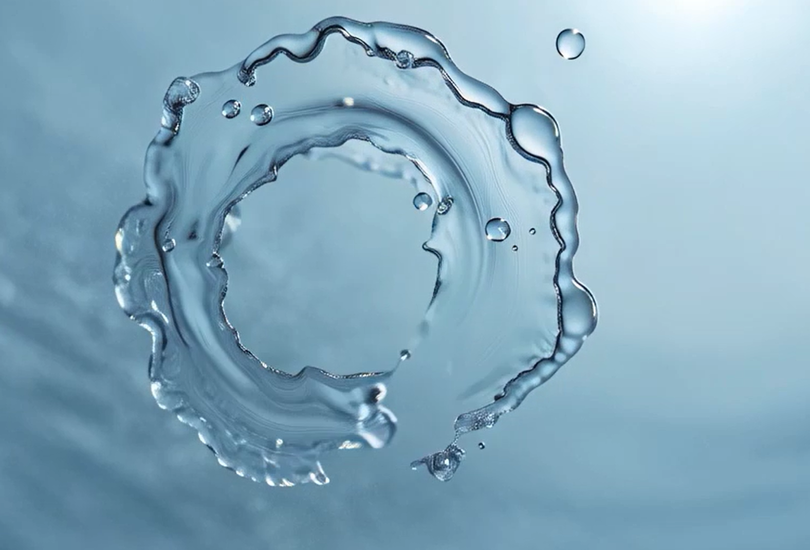 Close-up of a circular water splash forming a ripple ring on a light blue background, symbolizing clean water and sustainable innovation by Kemira.