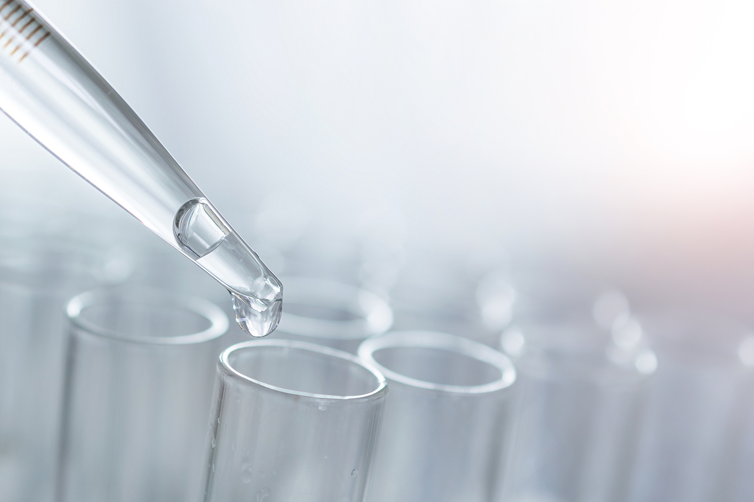 Laboratory pipette dispensing liquid into test tubes during scientific analysis.